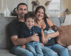 family of four with one young boy and a newborn